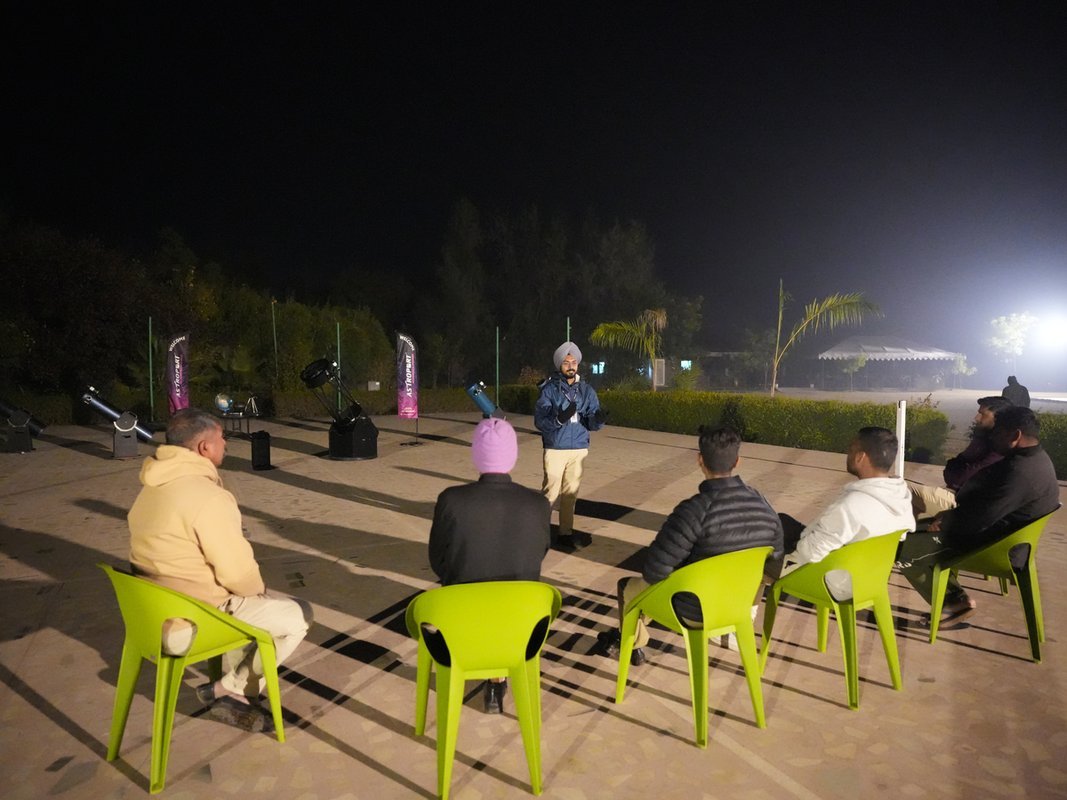 Guests seated outdoors watching the night sky during a stargazing session